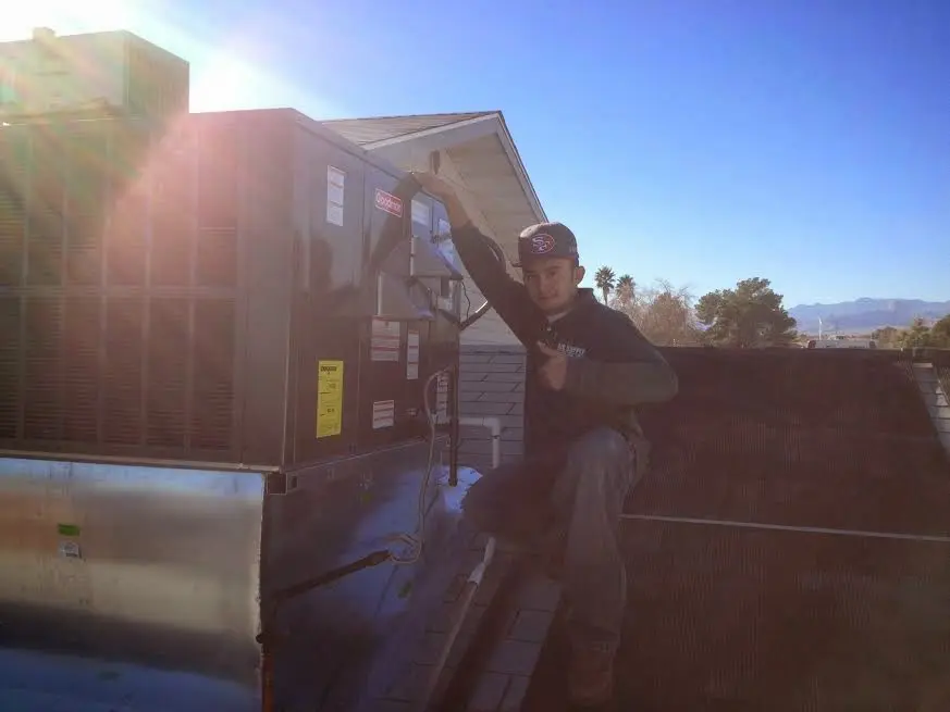 HVAC technician performing AC Tune-Up on a rooftop unit in Elmsford